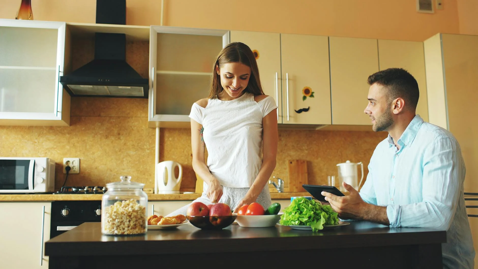 A couple enjoying meal preparation with fresh vegetables and fruit in a stylish kitchen. — Foto: Vitaly Gariev / Pexels
