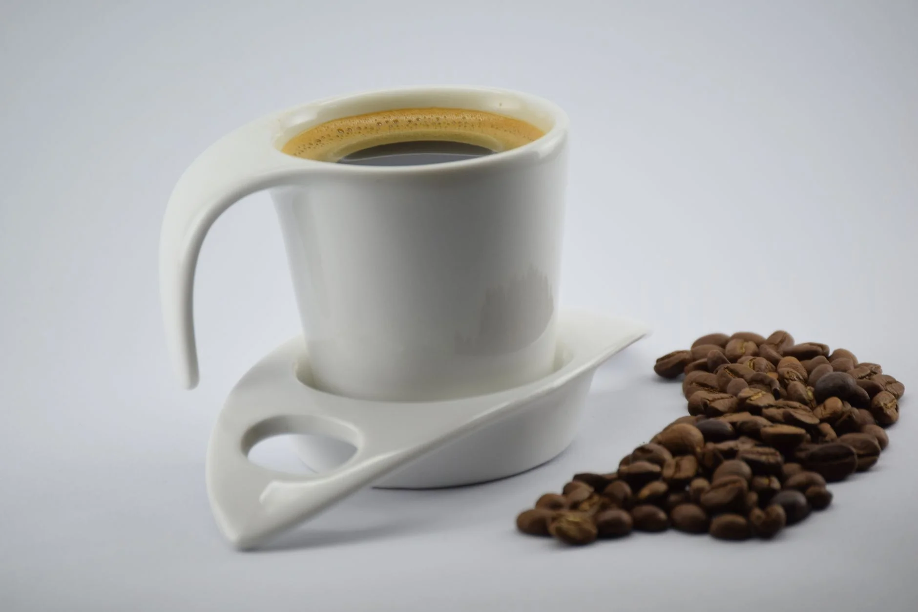 A photorealistic image of a person stretching confidently and smiling brightly in a sunlit office, looking refreshed and energized. They are wearing professional yet comfortable attire. The background shows a clean, modern workspace. Sharp focus on the person, depth of field blurring the office. 8K hyper-detailed, cinematic lighting, shot on a high-end DSLR. Stylish coffee cup with beans on a white background, perfect for minimalist design. — Foto: Fer Strange / Pexels
