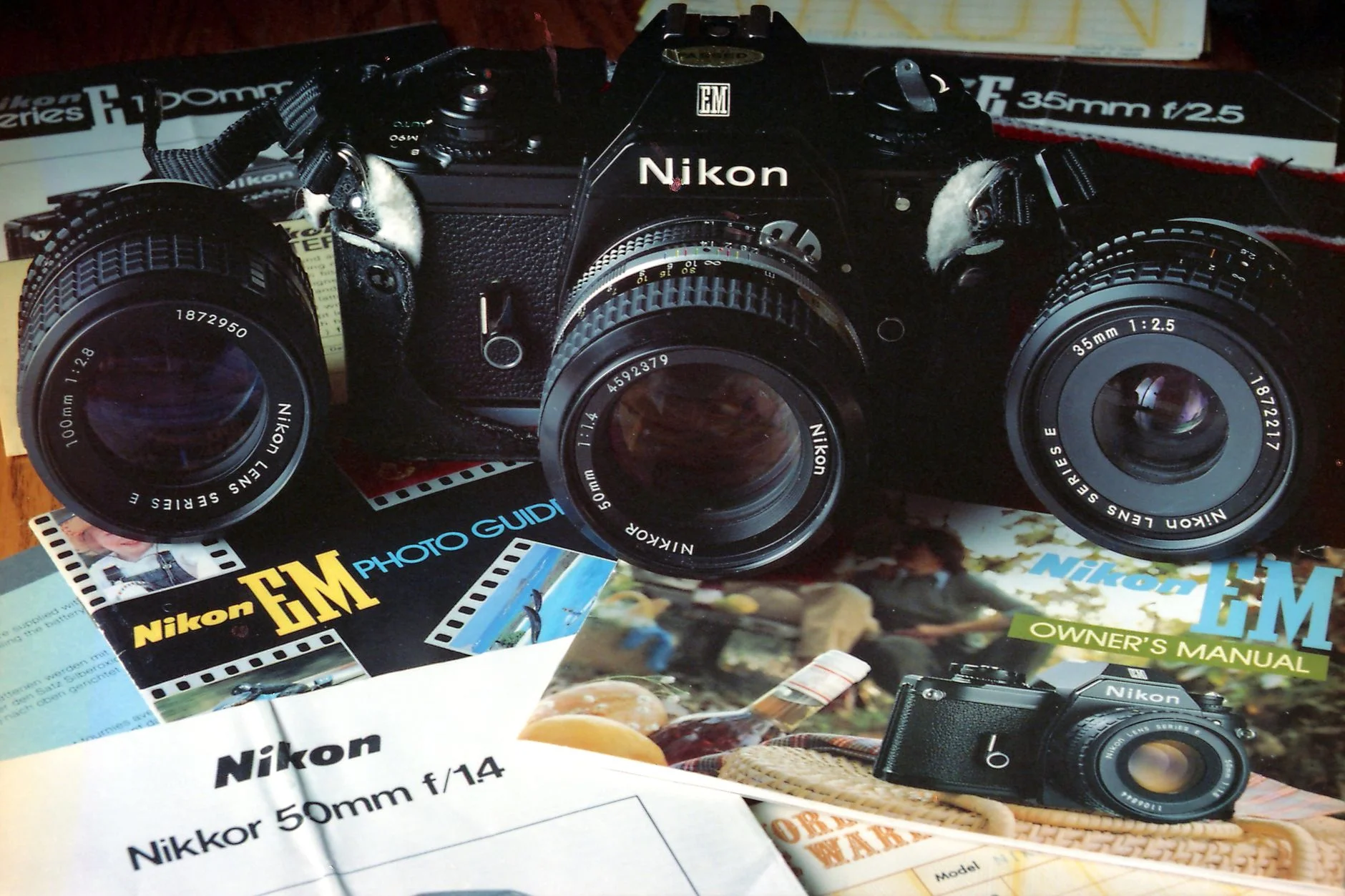A collection of Nikon SLR camera with lenses, brochures, and owner manuals. Perfect for vintage photography enthusiasts. — Foto: Alan Wang / Pexels