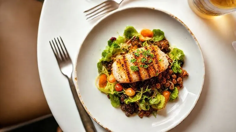 A visually appealing, photorealistic overhead shot of a perfectly plated, small gourmet Brazilian dish (e.g., a vibrant salad with grilled fish or a deconstructed feijoada) on a white table, with elegant cutlery. The dish looks fresh, healthy, and sophisticated, suggesting a quick and high-quality meal. Professional photography, 8K, cinematic lighting, sharp focus, depth of field.