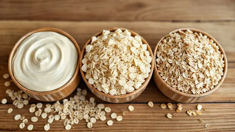 A photorealistic shot of three different bowls of oats side-by-side on a wooden table, each showing a distinct texture: one creamy and smooth (fine oats), one with visible, plump flakes (rolled oats), and one with a more granular, chewy consistency (steel-cut oats). Cinematic lighting, sharp focus on the textures, depth of field, 8K hyper-detailed.