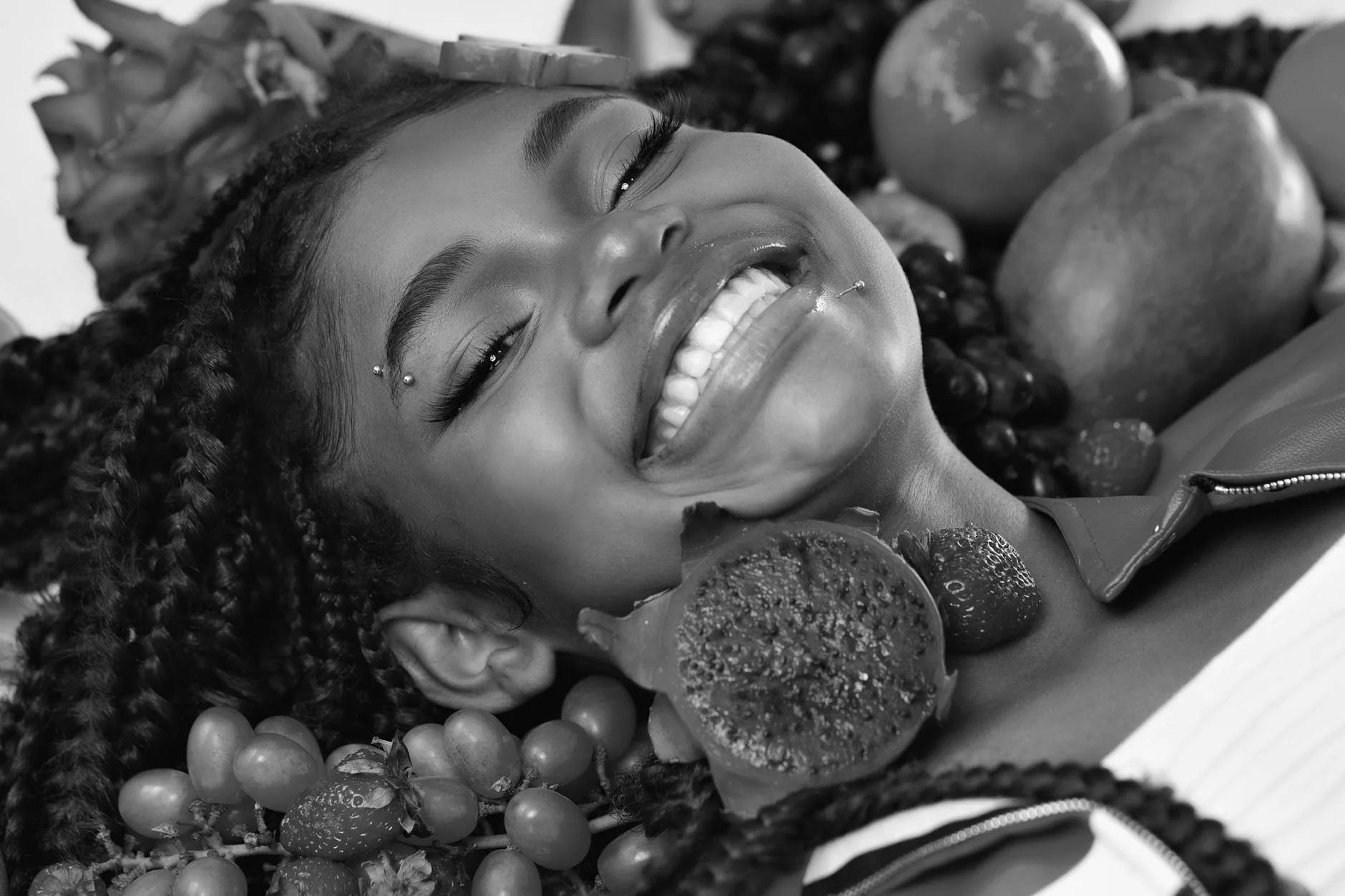 A cheerful woman surrounded by diverse Brazilian fruits, captured in a lively and colorful portrait. — Foto: Laura  Beauty Designer | Brasil / Pexels