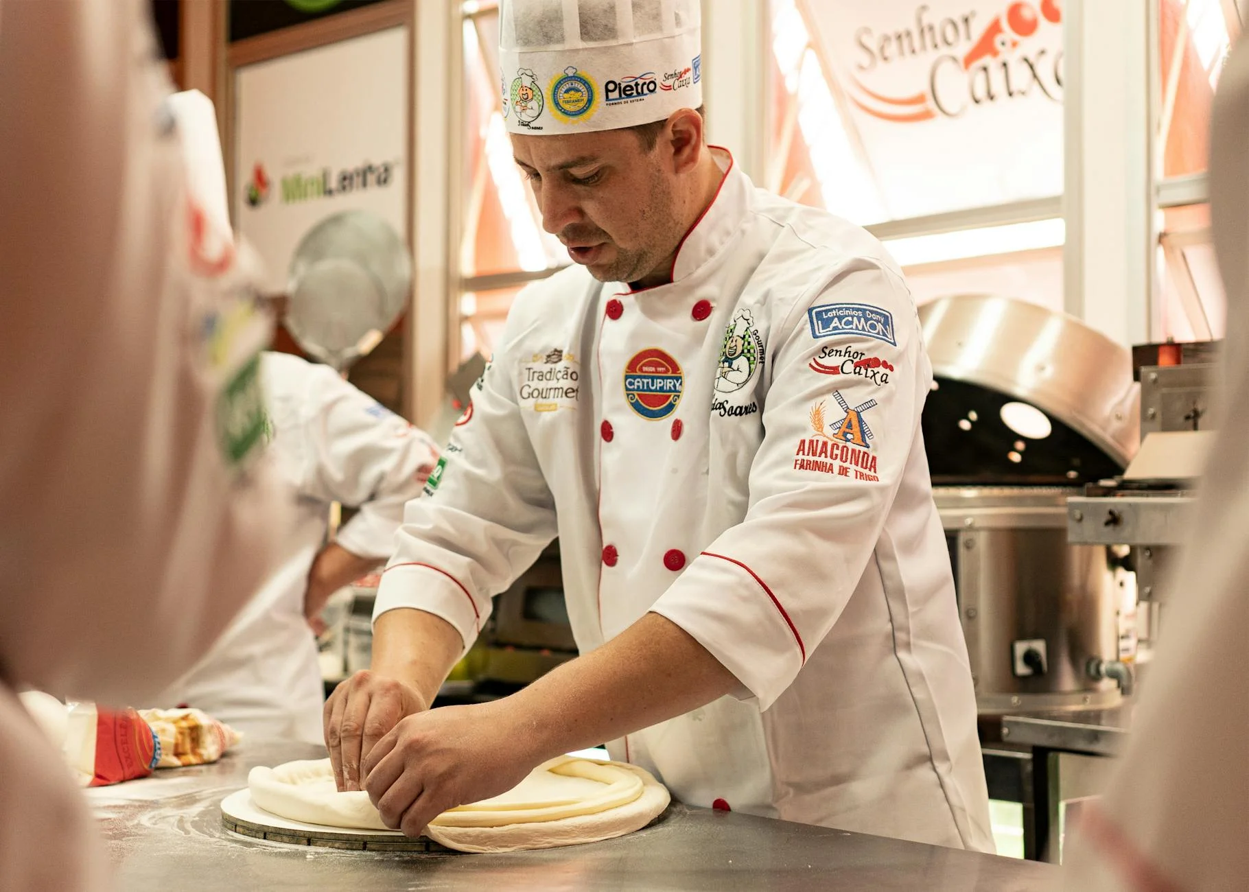 Chef kneading dough in a professional kitchen, showcasing culinary skills and uniform details. — Foto: Mario  Schafer / Pexels
